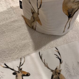 Dettaglio bordo tessuto Cervi Acquerello su asciugamano in spugna