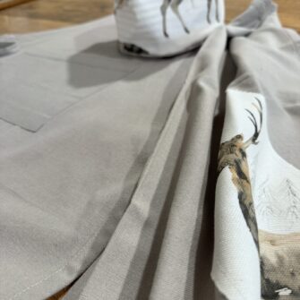 Dettaglio applicazioni in tessuto Cervi Acquerello su cotone tinta unita