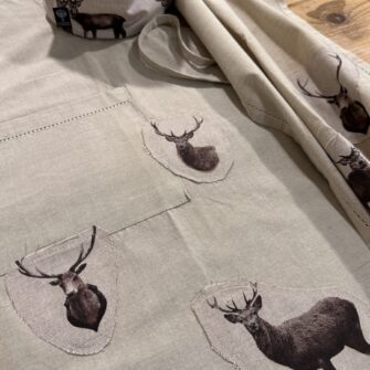 Dettaglio applicazioni in tessuto Cervi Acquerello su cotone tinta unita