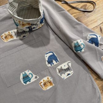 Dettaglio applicazioni in tessuto Gatti Azzurri su cotone tinta unita