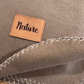 plaid in pile con orlo rifinito a punto cavallo