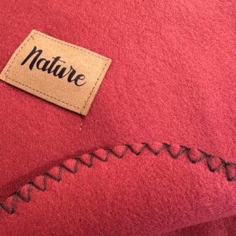 Plaid Nature Melograno. particolare la sua rifinitura con punto cavallo